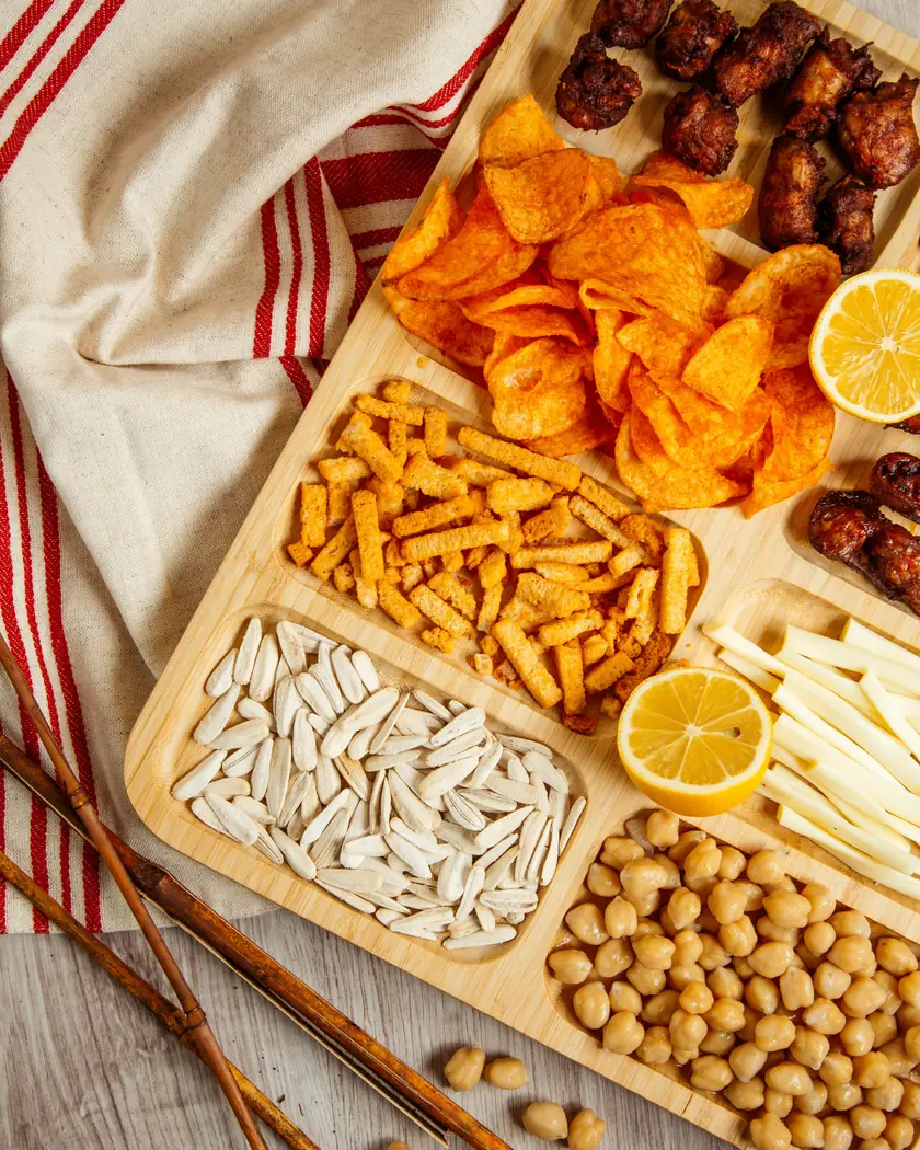 A board of crisps, nuts, seeds and savoury snacks